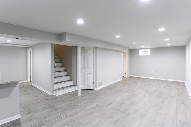 basement with light hardwood / wood-style flooring