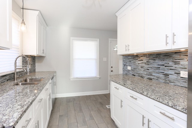 kitchen with decorative light fixtures, white cabinetry, tasteful backsplash, and sink