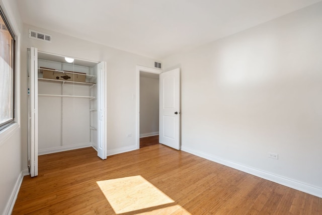 unfurnished bedroom featuring a closet and hardwood / wood-style floors