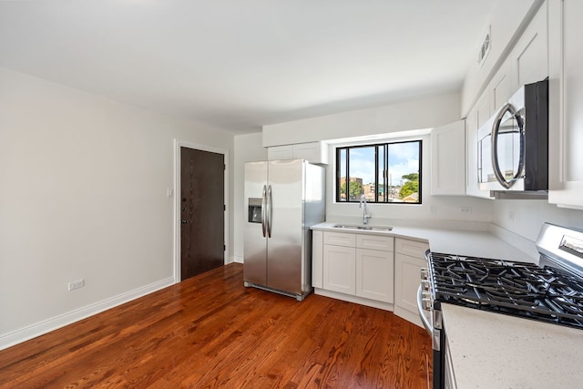 kitchen with white cabinets, stainless steel appliances, dark wood-type flooring, and sink