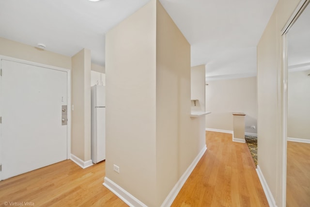 corridor with light hardwood / wood-style floors