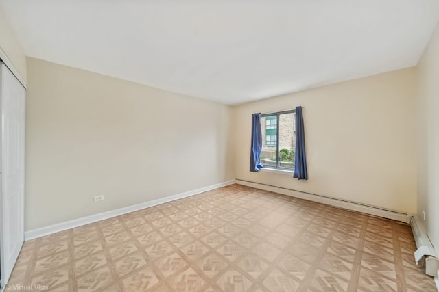 empty room with baseboard heating and light parquet floors