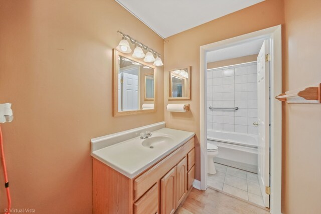 full bathroom featuring tile patterned floors, vanity, toilet, and tiled shower / bath