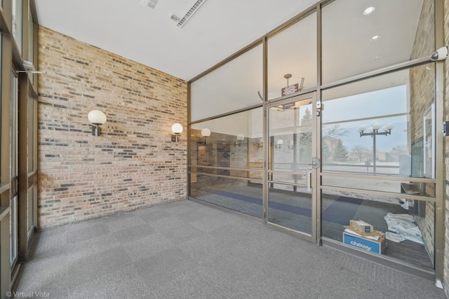 unfurnished room with carpet, brick wall, and vaulted ceiling