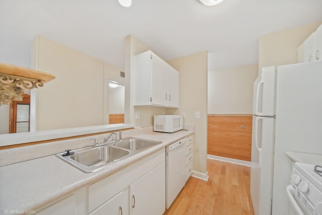 kitchen featuring white cabinetry, sink, light hardwood / wood-style floors, and white appliances