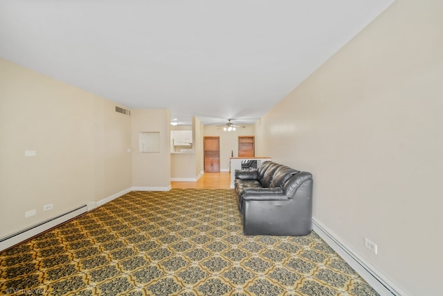 unfurnished room with carpet flooring, ceiling fan, and a baseboard radiator