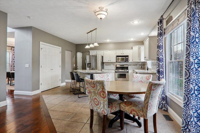 dining area with sink, light wood-type flooring, and a textured ceiling