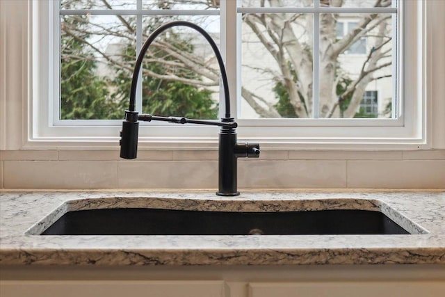 interior details with light stone countertops and sink