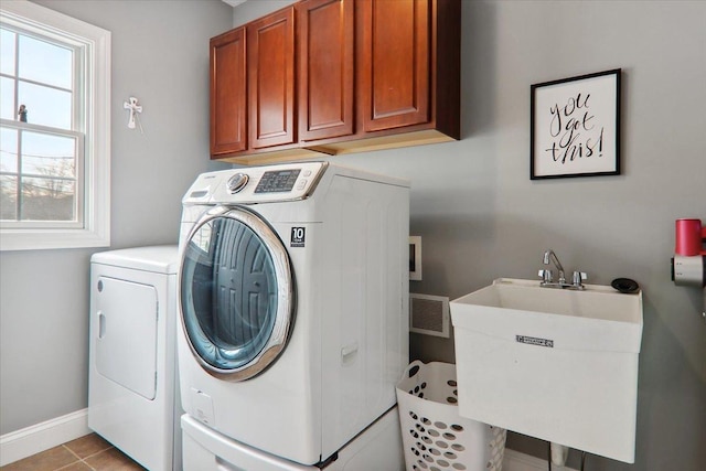 washroom featuring cabinets, light tile patterned floors, sink, and washing machine and clothes dryer