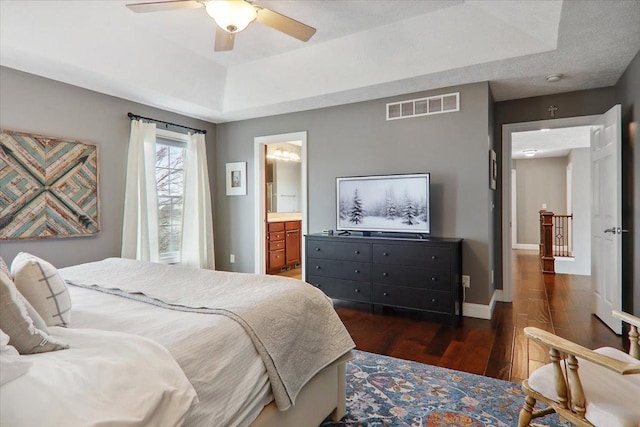 bedroom with connected bathroom, ceiling fan, and dark wood-type flooring