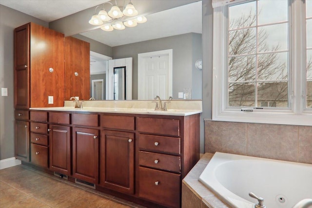 bathroom with tile patterned flooring, vanity, a chandelier, and tiled tub