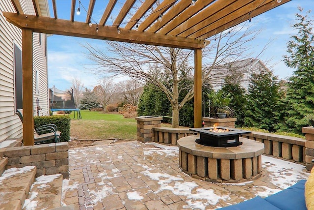 view of patio with a pergola, a trampoline, and an outdoor fire pit