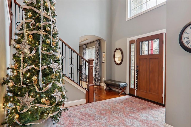 entryway featuring hardwood / wood-style flooring and a towering ceiling