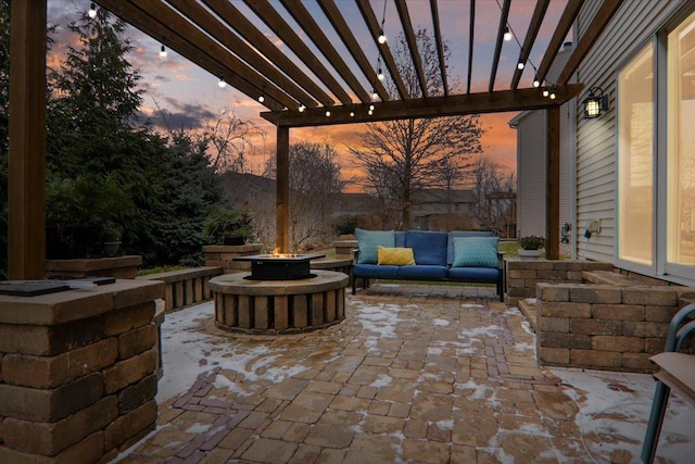 patio terrace at dusk with a pergola and an outdoor living space with a fire pit