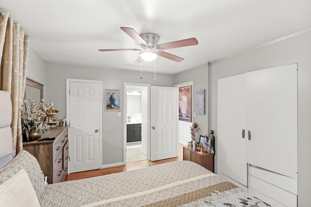 bedroom with ensuite bath, light hardwood / wood-style flooring, and ceiling fan