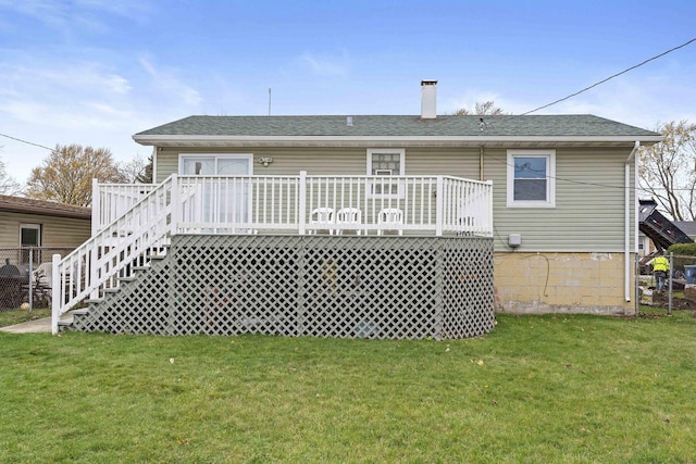 back of property featuring a lawn and a wooden deck