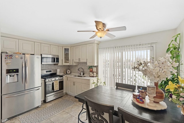 kitchen featuring ceiling fan, sink, cream cabinetry, light tile patterned floors, and appliances with stainless steel finishes