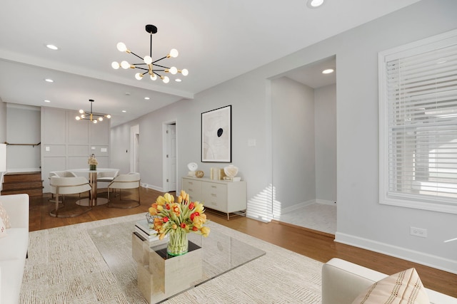 living room with hardwood / wood-style floors and a notable chandelier