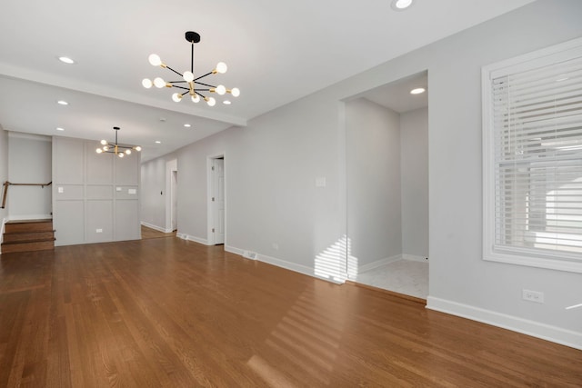 unfurnished living room with hardwood / wood-style floors and a chandelier