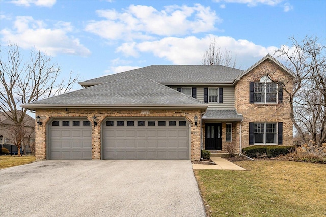 traditional home with brick siding, a shingled roof, an attached garage, driveway, and a front lawn