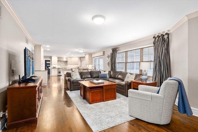 living area with baseboards, dark wood-style flooring, visible vents, and crown molding