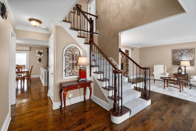 stairs with baseboards, wood-type flooring, and crown molding