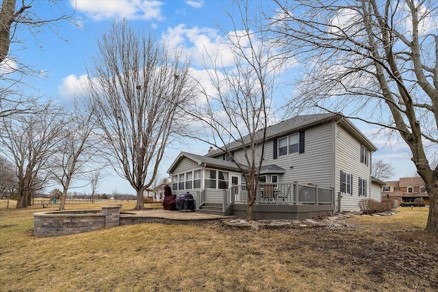 rear view of property featuring a sunroom, a yard, and a wooden deck