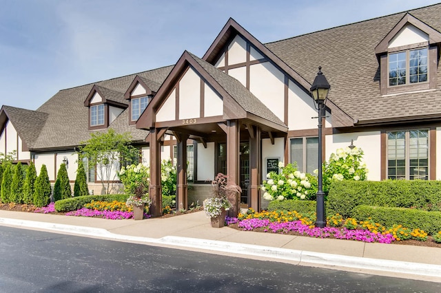 tudor house with roof with shingles and stucco siding