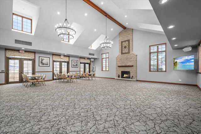 living area with high vaulted ceiling, a large fireplace, french doors, beam ceiling, and carpet