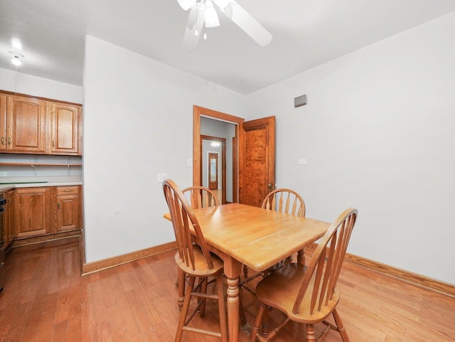 dining room with light hardwood / wood-style flooring and ceiling fan