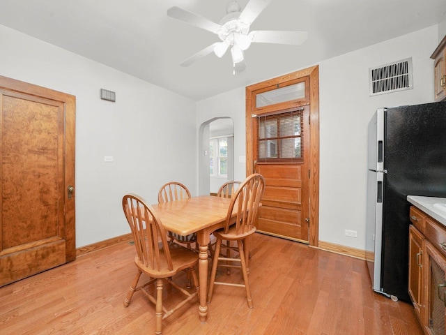 dining space with ceiling fan and light hardwood / wood-style flooring