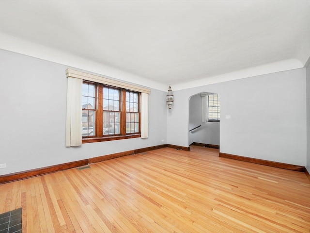 spare room with a wealth of natural light and hardwood / wood-style floors