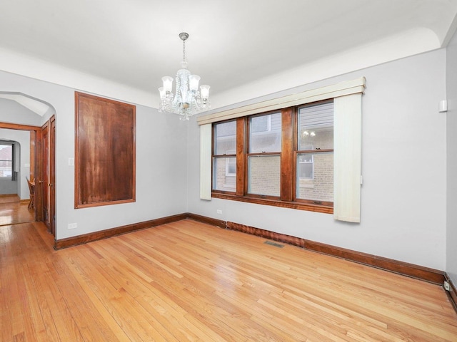 unfurnished dining area featuring a chandelier and light hardwood / wood-style floors