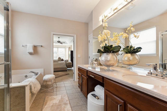 bathroom featuring tile patterned flooring, vanity, ceiling fan, and a bathing tub