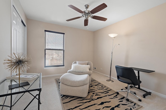 carpeted home office featuring ceiling fan