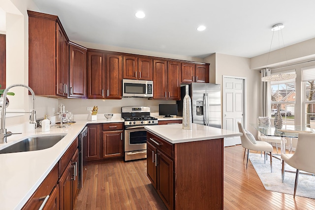 kitchen featuring sink, a kitchen island, stainless steel appliances, and hardwood / wood-style flooring