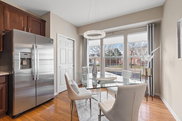 dining space with a chandelier and light hardwood / wood-style floors