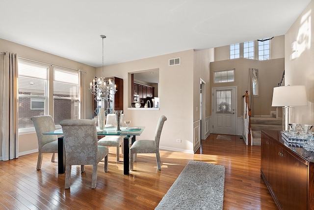 dining area with wood-type flooring and a notable chandelier