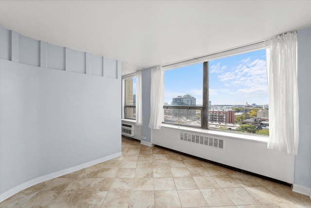 empty room with a healthy amount of sunlight and light tile patterned floors