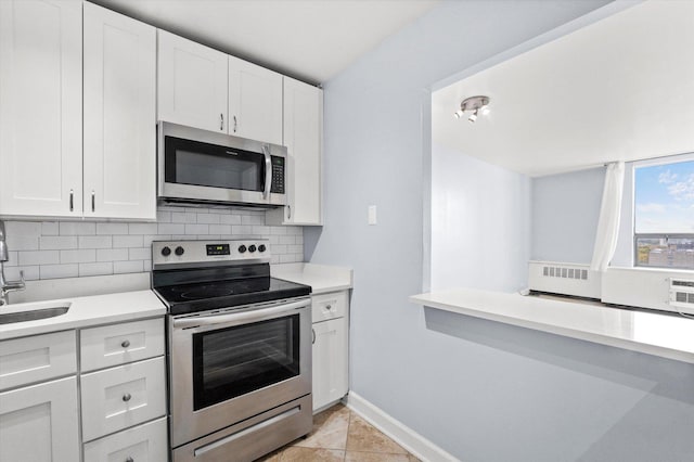 kitchen featuring white cabinets, light tile patterned floors, backsplash, and appliances with stainless steel finishes