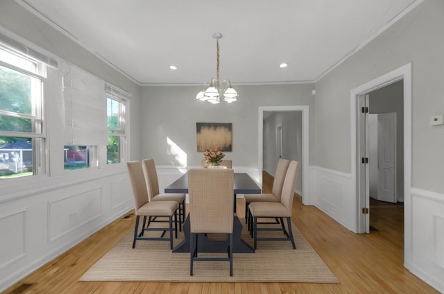 dining area featuring light hardwood / wood-style floors, an inviting chandelier, and ornamental molding