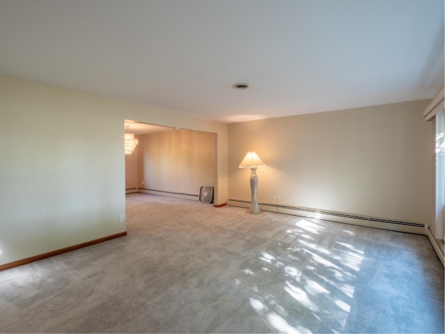 carpeted empty room featuring baseboard heating and a notable chandelier