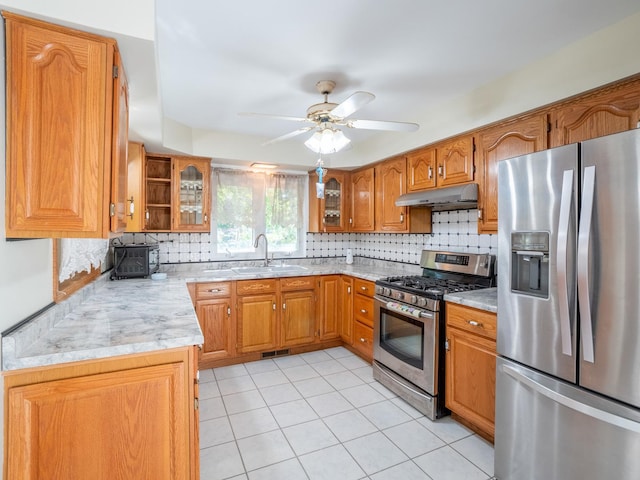 kitchen with sink, ceiling fan, light tile patterned floors, tasteful backsplash, and stainless steel appliances