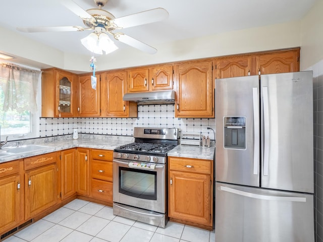 kitchen with ceiling fan, sink, tasteful backsplash, light tile patterned flooring, and appliances with stainless steel finishes