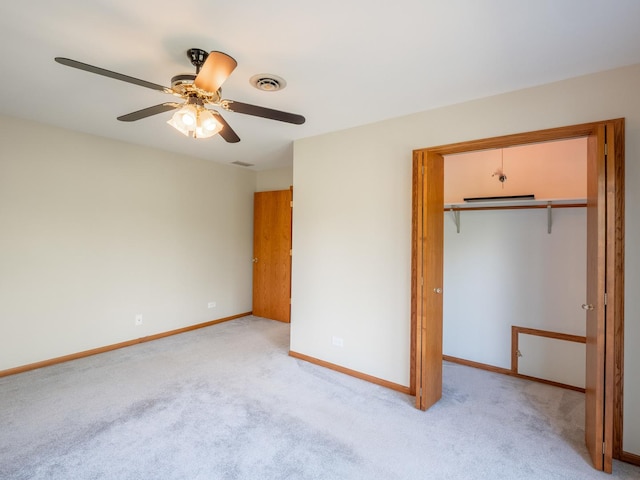 unfurnished bedroom featuring ceiling fan, a closet, and light carpet