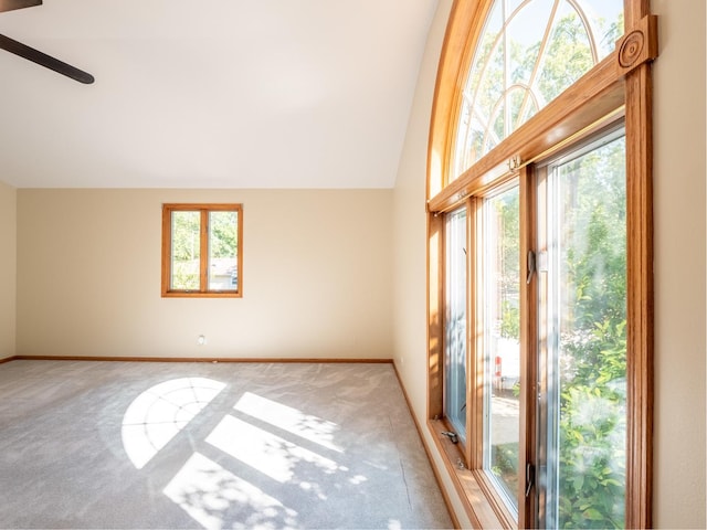 carpeted spare room with ceiling fan and high vaulted ceiling