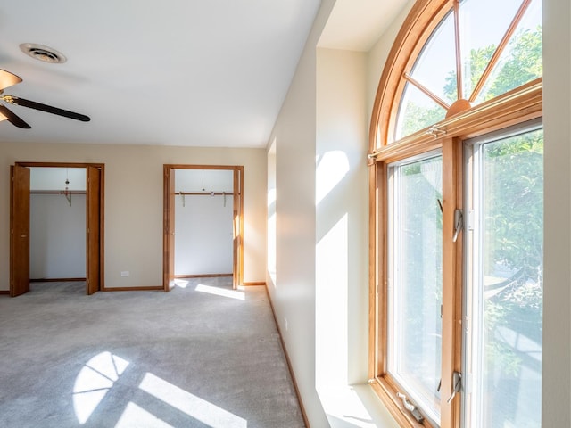 interior space with ceiling fan and light carpet