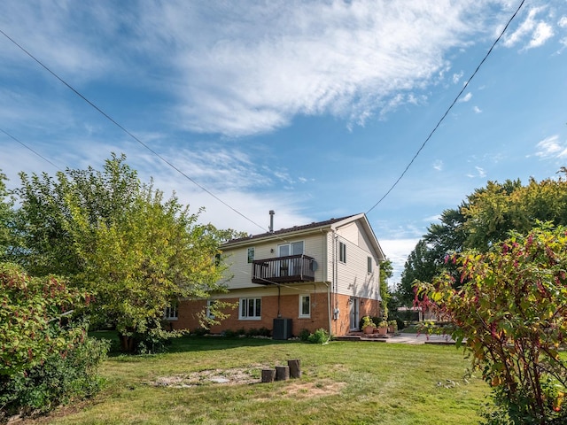 rear view of house featuring a yard, a balcony, cooling unit, and a patio