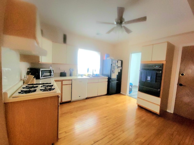 kitchen featuring light wood-type flooring, white cabinetry, and black appliances