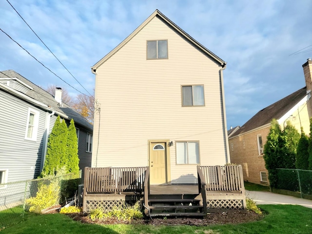 back of property with a lawn and a wooden deck